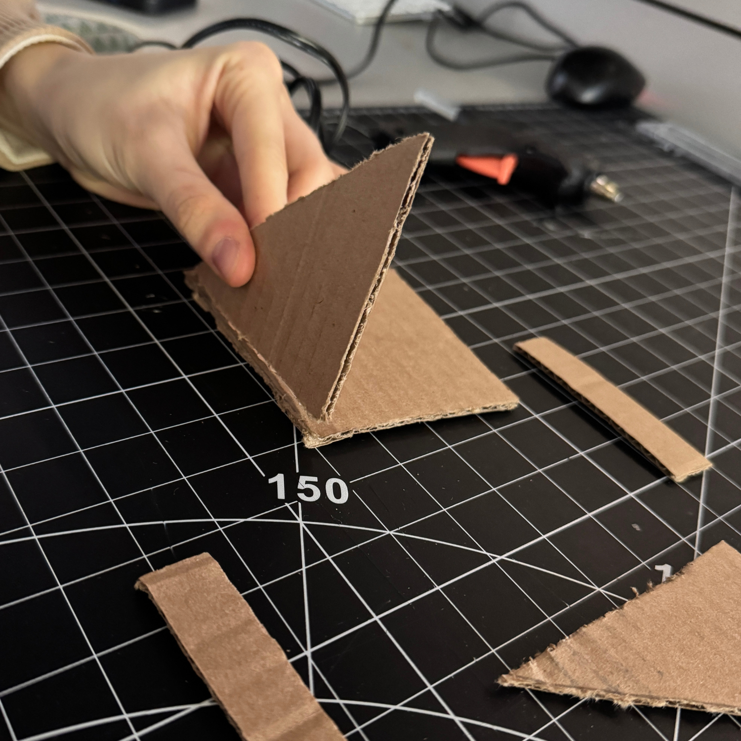 Following the youtube tutorial we cut out all the pieces we needed and started by gluing on the triangle sides.